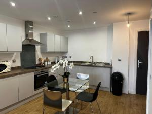 a kitchen with a glass table and chairs in it at At home Property in Manchester
