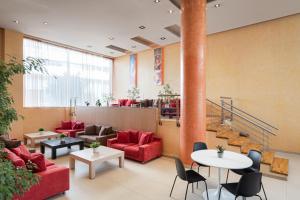 a lobby with red couches and tables and a column at Lacoba Hotel in Athens