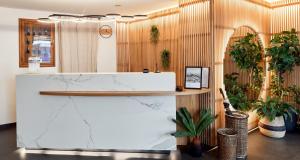 a lobby with a marble counter and potted plants at Best Western Aramis Saint Germain in Paris