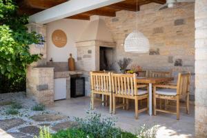 una cocina al aire libre con mesa de madera y sillas en Villa Vin with 2 bedrooms and pool in Porec, en Nova Vas