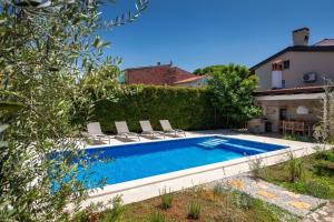 una piscina con sillas y una casa en Villa Vin with 2 bedrooms and pool in Porec, en Nova Vas