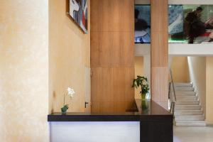 a lobby with a staircase and a table with flowers at Lacoba Hotel in Athens