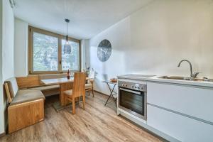una cucina e una sala da pranzo con tavolo e lavandino di Apartment Römerbrücke - Ponte Romano a Merano