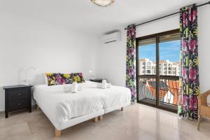 Un dormitorio blanco con una cama y una ventana grande. en Lovely penthouse by Costarentals - Ref M15, en Estepona 43 fotos más