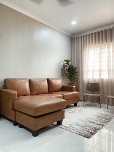 a brown leather couch in a living room with a window at Seaview apartment in Kuala Terengganu