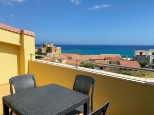a table and chairs on a balcony with a view of the ocean at Marina di Petrolo Apartments in Castellammare del Golfo