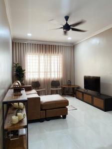 ein Wohnzimmer mit einem Sofa und einem Deckenventilator in der Unterkunft Seaview apartment in Kuala Terengganu