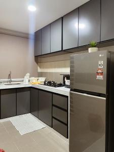 a kitchen with black and white cabinets and a refrigerator at Seaview apartment in Kuala Terengganu