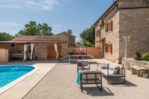 a patio with a pool and chairs next to a building at House Casa Smolica in Krnica