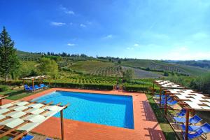 a pool with chairs and a view of a vineyard at Casa Rossa by PosarelliVillas in Luia