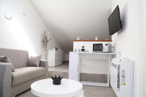 un soggiorno con divano e forno a microonde di Al civico 5 - Mondern Apartments & Suite! a Decimomannu