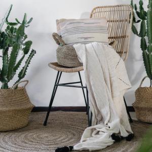 a blanket on a chair in a room with plants at OKU - soulful suites in Casale Marittimo