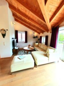 ein Wohnzimmer mit zwei weißen Sofas und einer Holzdecke in der Unterkunft Ferienwohnung Chiemseezauber 