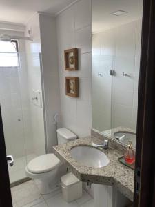 ein Badezimmer mit Toilette, Waschbecken und Dusche in der Unterkunft Condomínio Barra Bali apartamento térreo de frente para mar in Barra de São Miguel