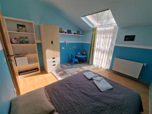 ein blaues Schlafzimmer mit einem Bett und einem Fenster in der Unterkunft Harmony Haven in Cluj-Napoca