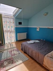 a bedroom with a bed and a blue wall at Harmony Haven in Cluj-Napoca