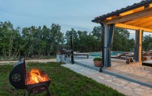 a fire pit in a yard next to a pool at Modern villa Bibali Istra with pool in Buje in Bibali