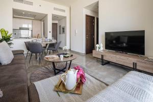 uma sala de estar com um sofá, uma televisão e uma mesa em Frank Porter - Majestique Residence 2 em Dubai