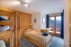 a bedroom with two bunk beds and a desk with a window at Beauvoir 318 in Verbier