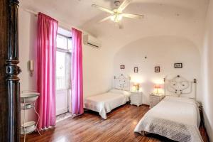 um quarto com 2 camas e cortinas cor-de-rosa em Retreat of the Senses em Massa Lubrense