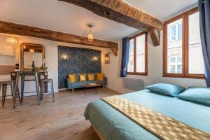 1 dormitorio con cama, mesa y sofá en Le Romantique jacuzzi centre ville, en Rouen