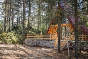 a cabin in the woods with a fence and trees at Peace of mind in Žabljak +11 photos