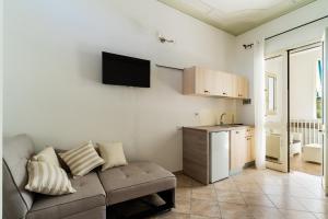 een woonkamer met een bank en een keuken bij Appartamento Verde 1 in Castrignano del Capo
