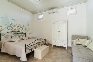 een slaapkamer met een bed en een bank bij Appartamento Verde 1 in Castrignano del Capo