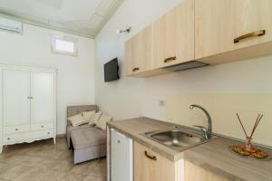una cocina con fregadero y un sofá en una habitación en Appartamento Verde 1, en Castrignano del Capo