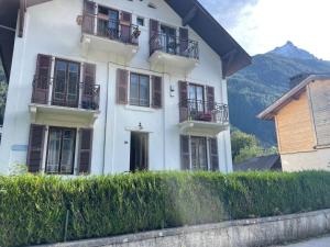 a white house with balconies on top of a hedge at A Room in Grands Charmoz in Chamonix-Mont-Blanc