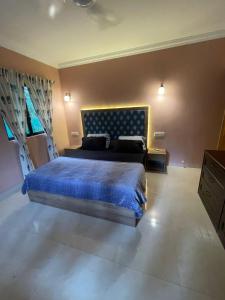 a bedroom with a large bed with a blue bedspread at Riviera Residency luxury apartment in Arpora