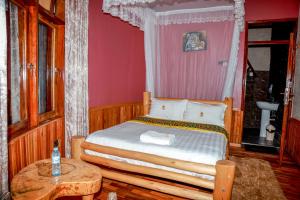 a bedroom with a bed and a table in it at Masaka Cultural Resort in Masaka