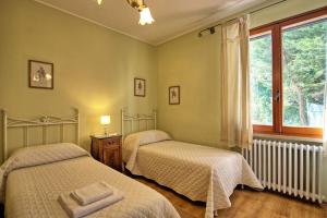 two beds in a bedroom with a window at Casa Rossa by PosarelliVillas in Luia