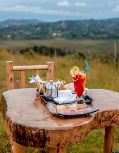 a wooden table with a tray of food and drinks on it at Masaka Cultural Resort in Masaka