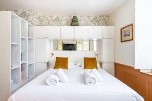 a bedroom with a bed with white cabinets and yellow pillows at La Réserve de Salon de Provence in Salon-de-Provence