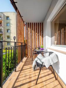 a balcony with a table and chairs on a balcony at Gdynia Wyjątkowy Apartament przy Lesie by Renters in Gdynia