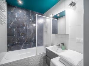 a bathroom with a tub and a sink and a shower at Gdynia Wyjątkowy Apartament przy Lesie by Noclegi Renters in Gdynia