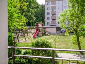 a playground with a red slide in a park at Gdynia Wyjątkowy Apartament przy Lesie by Renters in Gdynia