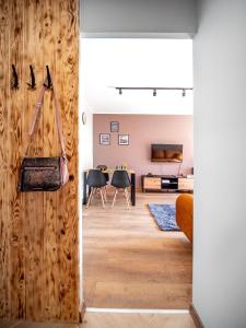 a living room with a wooden wall and a table at Gdynia Wyjątkowy Apartament przy Lesie by Noclegi Renters in Gdynia