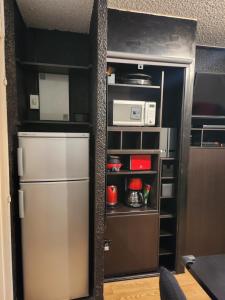 uma cozinha com um frigorífico e um micro-ondas em La Petite Corneille - a chic and central studio. em Le Monêtier-les-Bains