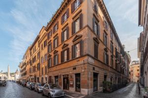een groot bakstenen gebouw met auto's geparkeerd op een straat bij Lovely Apartment ad un passo da Piazza del Popolo! in Rome