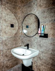 a bathroom with a sink and a mirror on the wall at Masaka Cultural Resort in Masaka