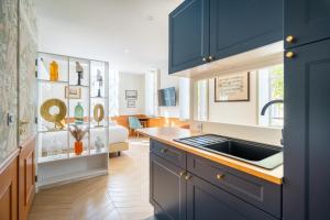 uma cozinha com armários azuis e um lavatório em La Réserve de Salon de Provence em Salon-de-Provence