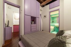a bedroom with a purple wall with a bed and a bathroom at Lovely Apartment ad un passo da Piazza del Popolo! in Rome