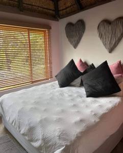 a bedroom with a bed with two hearts on the wall at Bosveldsig Cottages in Modimolle