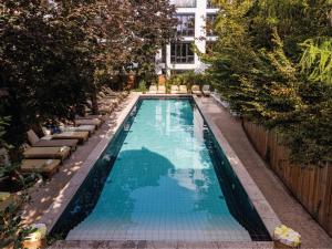 uma piscina vazia com espreguiçadeiras e árvores em MOB House em Saint-Ouen
