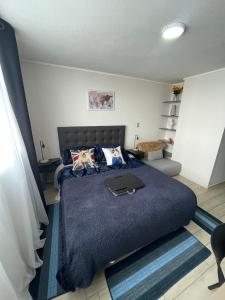 um quarto com uma cama grande e um cobertor azul em Apartamento en Santiago centro cerca de movistar arena, caupolican em Santiago