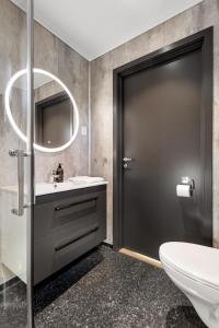 a bathroom with a toilet and a sink and a mirror at Kviltorp Camping in Molde +66 photos