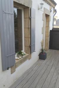 eine Veranda mit zwei Türen und zwei Topfpflanzen in der Unterkunft locmiquélic petite maison de pêcheur in Locmiquélic