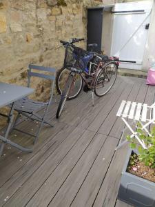 uma bicicleta estacionada ao lado de uma mesa e uma cadeira em locmiquélic petite maison de pêcheur em Locmiquélic